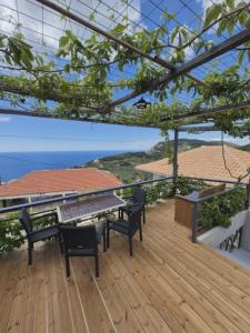 a deck with a table and chairs and the ocean at Ionian Balcony in Athani