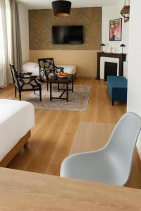 a living room with a white couch and a fireplace at Hotel La Baie Royale in Pontorson