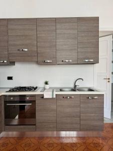 a kitchen with wooden cabinets and a sink at Mary 's Home in Caserta