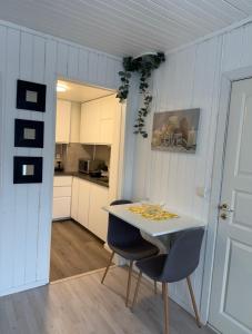 a kitchen with a white table and two chairs at Koselig leilighet in Flekkefjord