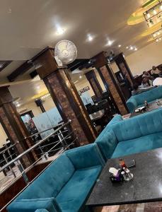 a living room with a blue couch and a table at Solo Hotel in Sargodha