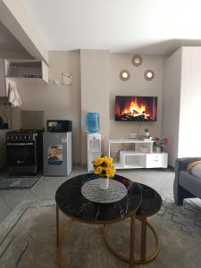 a living room with a table and a fireplace at Pearls Haven in Kinoo