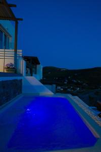 a pool with blue lights on the side of a house at Vista Mare Suites in Kithnos +30 photos