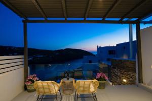 a balcony with chairs and a view of the ocean at Vista Mare Suites in Kithnos