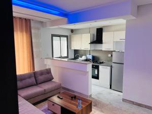 a living room with a couch and a kitchen at Modern Oasis near Airport & Lac 2 - Wahat Aouina in El Aouina Station