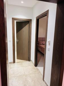 a hallway with two doors and a room with a couch at Modern Oasis near Airport & Lac 2 - Wahat Aouina in El Aouina Station