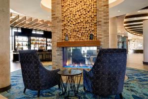 a lobby with two chairs and a fireplace at Archer Hotel Florham Park in Florham Park