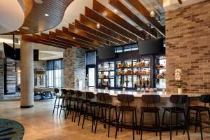 a bar in a restaurant with a bunch of stools at Archer Hotel Florham Park in Florham Park