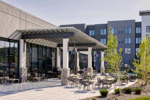 a patio with tables and chairs in front of a building at Archer Hotel Florham Park in Florham Park