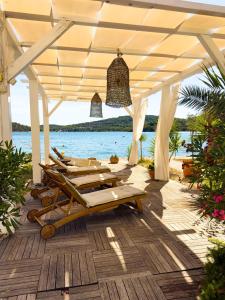 a group of lounge chairs under a pavilion on the beach at Apartments Antonio in Tisno