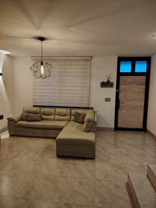 ein Wohnzimmer mit Sofa und Fenster in der Unterkunft Casa Puzzle in El Nido