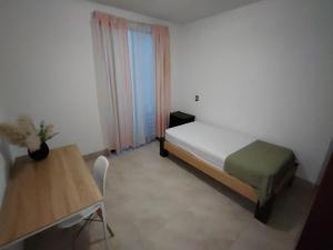 ein kleines Schlafzimmer mit einem Bett und einem Tisch in der Unterkunft Casa Puzzle in El Nido