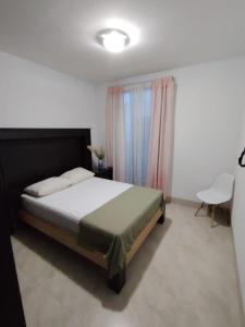 ein Schlafzimmer mit einem Bett, einem Tisch und einem Stuhl in der Unterkunft Casa Puzzle in El Nido