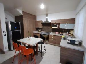 eine Küche mit einem Tisch und orangefarbenen Stühlen in der Unterkunft Casa Puzzle in El Nido