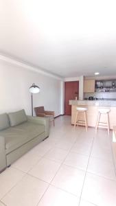 a living room with a couch and a kitchen at Kariri Beach Waterfront Retreat in Caucaia