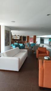 a living room with a white couch and chairs at Kariri Beach Waterfront Retreat in Caucaia