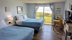a hotel room with two beds and a balcony at Silver Surf Motel in Yachats +30 photos
