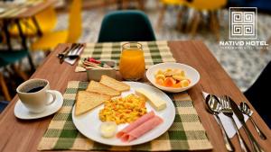 a table with a plate of breakfast food and a cup of coffee at Nativo Hotel in Popayan +34 photos