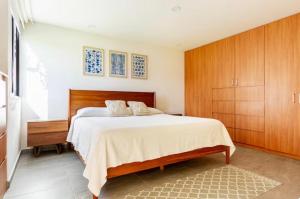 a bedroom with a large bed and wooden cabinets at CASA CON JACUZZI PRIVADO PARA 6 personas in Tequisquiapan +35 photos