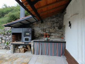 an outdoor kitchen with a stove and a stone wall at Mirador del Buitre in Soto en Cameros