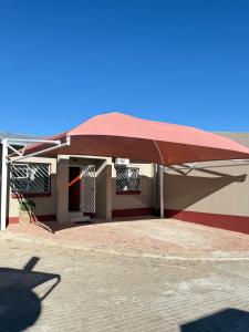 a large red umbrella in front of a building at Casa Bonheur in Windhoek