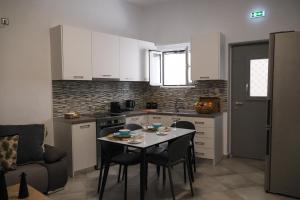a kitchen with a table and chairs and a kitchen with white cabinets at Antel apartment in Naousa