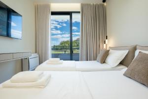 two beds in a hotel room with a window at Villa Cosmo Panorama in Rrashbull +38 photos