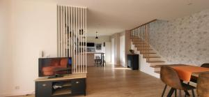 a living room with a dining table and a staircase at Maison au calme in Nogent-sur-Eure