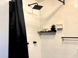 a bathroom with a shower with a black door at Hotel Homsty in San Martín Texmelucan de Labastida