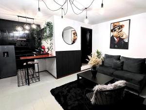 a living room with a black couch and a kitchen at Hotel Homsty in San Martín Texmelucan de Labastida +52 photos