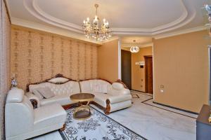 a living room with white furniture and a chandelier at Luxury Apartament in Amiryan Street Nerby Republic Square in Yerevan