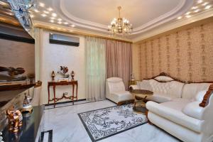 a living room with a white couch and a chandelier at Luxury Apartament in Amiryan Street Nerby Republic Square in Yerevan