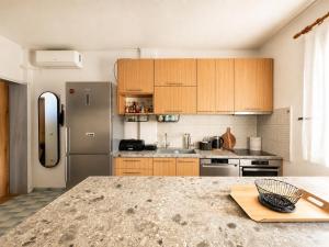 a kitchen with wooden cabinets and a stainless steel refrigerator at Villa Pilgrimos in Ierissos