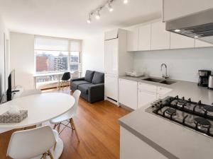 a kitchen and living room with a table and a couch at Moden & Cozy Downtown Condo in Vancouver in Vancouver