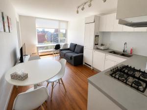 a kitchen and living room with a white table and chairs at Moden & Cozy Downtown Condo in Vancouver in Vancouver