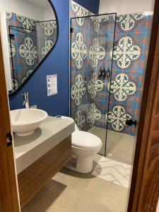 a bathroom with a toilet and a sink and a shower at Nativo Hotel in Popayan