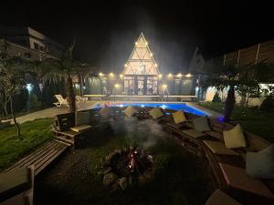 a fire pit in front of a building at night at Qafqaz Mountside Chalet in Gabala