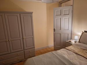 a bedroom with a bed and a closet and a door at Gweedore Seaview Cottage in Bun na Leaca