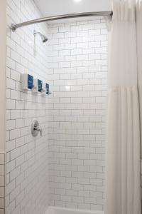 a white tiled shower with a shower curtain at Tofino Resort + Marina in Tofino +92 photos