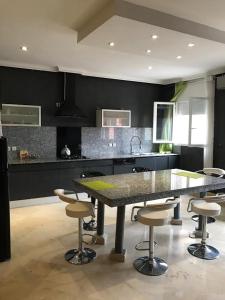 a kitchen with a table and bar stools in it at Etablissement moderne in Safi