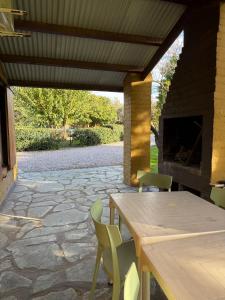 a patio with a table and chairs and a fireplace at Cabañas Ojo de Agua in Sierra de la Ventana