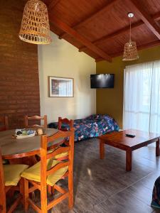 a living room with a table and a bed at Cabañas Ojo de Agua in Sierra de la Ventana