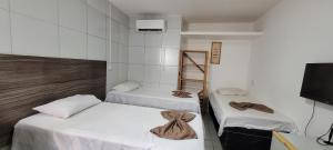 a room with two beds and a tv and a room with at Pousada Primeiro Sol in João Pessoa +101 photos