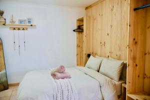 a bedroom with a bed with a pink toy on it at De Schelde Beach Cottage in Wilderness