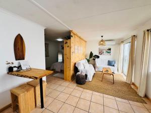 a living room with a couch and a table at De Schelde Beach Cottage in Wilderness