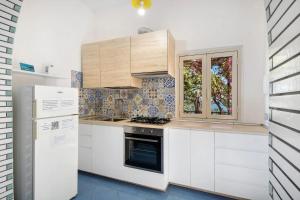a kitchen with white cabinets and a stove at Blue & Green Apartments in Erchie