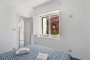 a white bedroom with a bed and a window at Blue & Green Apartments in Erchie
