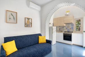 a living room with a blue couch in front of a kitchen at Blue & Green Apartments in Erchie