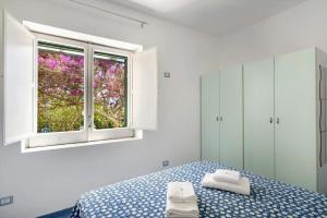 a bedroom with a bed and a window at Blue & Green Apartments in Erchie +27 photos