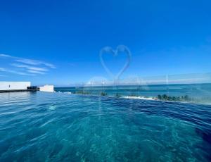 a view of the ocean with a heart in the sky at Private Suite, Walk to the Beach, Oceanview Rooftop Pool, WiFi StarLink in Puerto Morelos